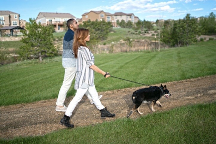 Couple walks dog on trail in Anthem Highlands