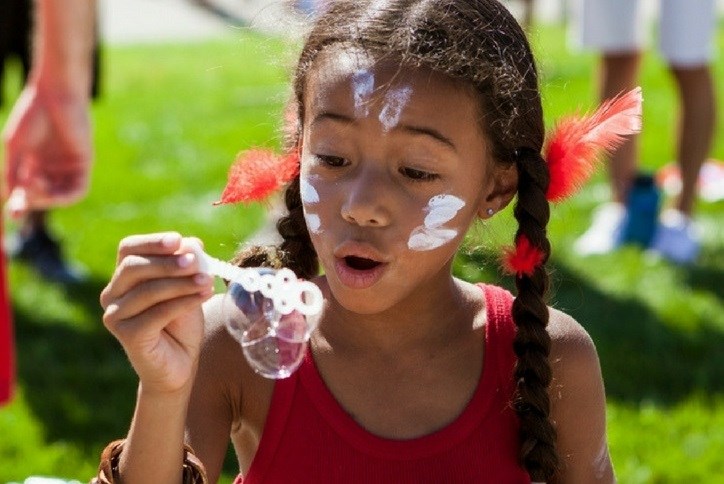 Girl blowing bubbles at event in Anthem